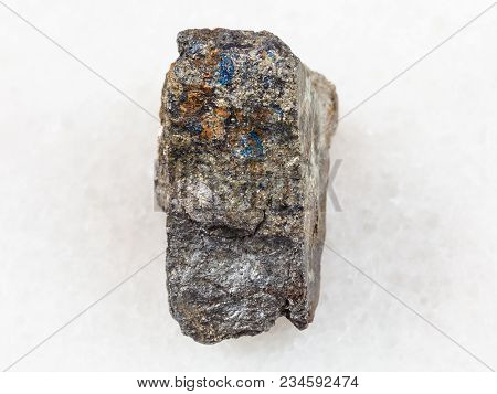 Macro Shooting Of Natural Mineral Rock Specimen - Piece Of Arsenopyrite Stone On White Marble Backgr