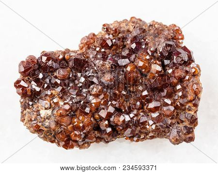 Macro Shooting Of Natural Mineral Rock Specimen - Raw Andradite Garnet Crystals On Stone On White Ma