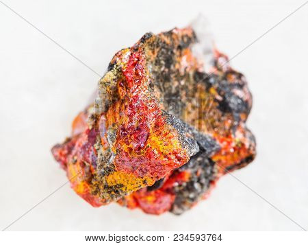 Macro Shooting Of Natural Mineral Rock Specimen - Rough Realgar Crystals On Stone On White Marble Ba