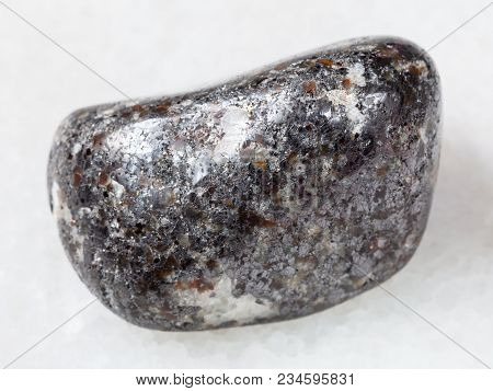Macro Shooting Of Natural Mineral Rock Specimen - Pebble Of Magnetite Stone On White Marble Backgrou