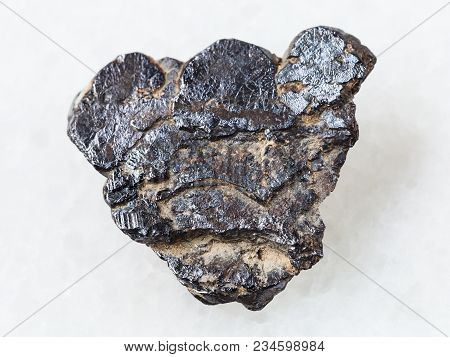 Macro Shooting Of Natural Mineral Rock Specimen - Raw Ilmenite Stone On White Marble Background From
