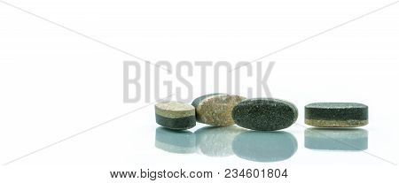 Essential Vitamins And Minerals Supplements Dual Layer Tablet Pills Isolated On White Background. Mu