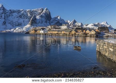 Fishermen Cabins Or Rorbuer, Mountains And Water At Sikrisoya, Lofoten, Norway