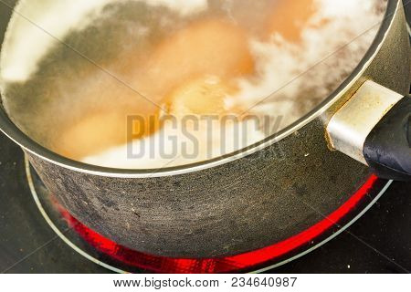 Closeup On Cooking Eggs In A Pot Of Water On A Ceramic Hob
