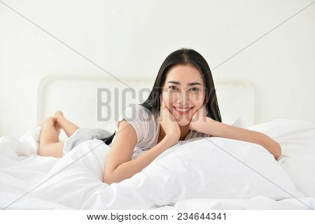 Lifestyle Concept. Cute Asian Girl In Night Dress. Beautiful Asian Woman Is Relaxing In A White Bedr