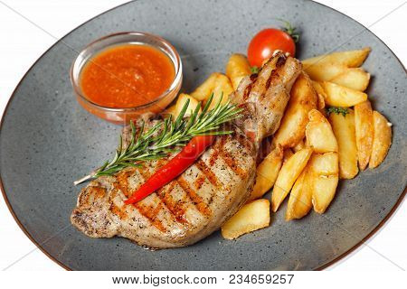 Fried Meat With Garnish Of Pepper, Zucchini, Tomato And Corn With Ajika Sauce Served On A Gray Plate