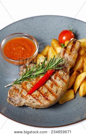 Fried Meat With Garnish Of Pepper, Zucchini, Tomato And Corn With Ajika Sauce Served On A Gray Plate