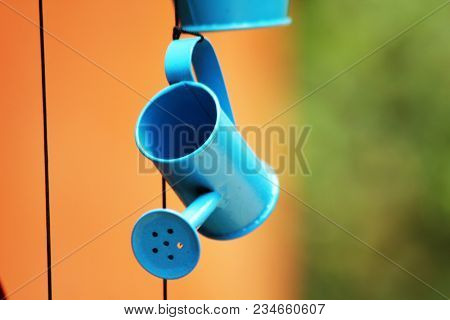 Watering Can Blue Is Hanging With A Rope To Decorate.