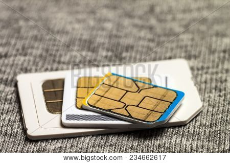 Set Of Mini, Micro And Nano Simcard. Isolated On Grey Cloth Texture Background
