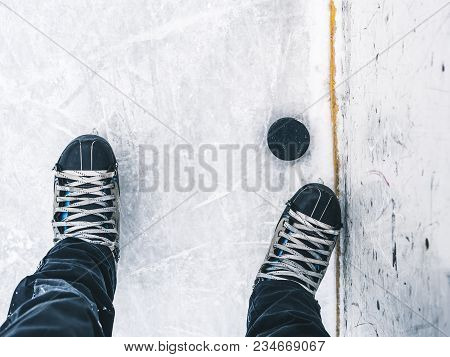 Top Down View Of Hockey Puck And Skates On Ice