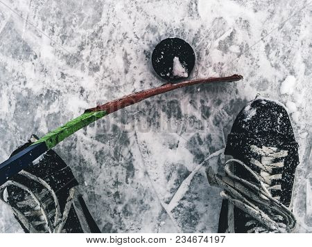 Top Down View Of Hockey Puck And Skates On Ice