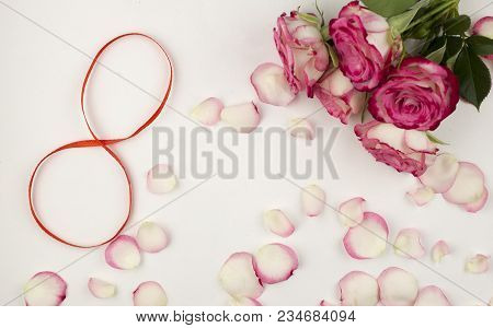 Digit 8 On White Background And Rose Petals