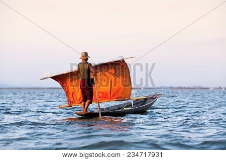 An Unidentified Fisherman Of Intha Tribe People In Wooden Boat Floating In Wooden Boat With Orange S