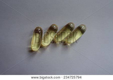 Macro Of Four Yellow Fish Oil Capsules