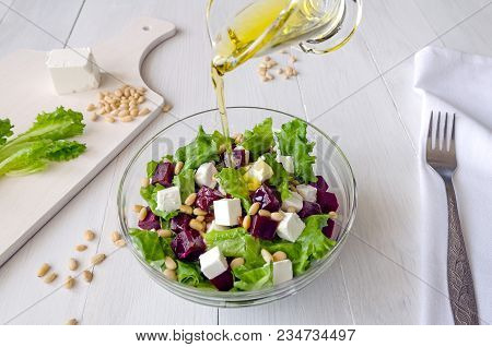 Salad Of Beetroot, Feta Cheese And Lettuce Leaves With Pine Nuts Poured With Olive Oil White Wooden 