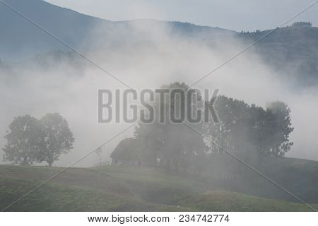 Beautiful Mountain Landscape Of A Foggy Morning With And Old House, Trees And Clouds, Dumesti, Salci