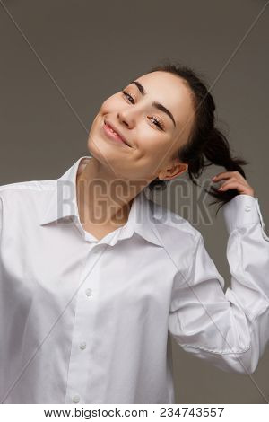 Beautiful Girl In A White Shirt Shows Emotions - Smile, Fun. On A Light Background.