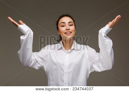 Beautiful Girl In A White Shirt Shows Emotions. On A Light Background.