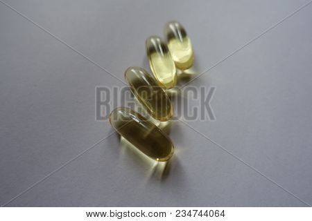 Close Shot Of Four Yellow Fish Oil Capsules