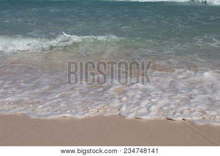 Waves Crashing On A Pink Sand Beach
