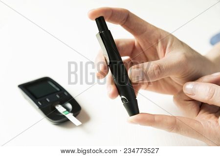 Diabetes Checking Blood Sugar Level. Woman Using Lancelet And Glucometer At Home