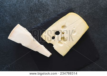 An Appetizing Solid Cheese On A Black Plate On A Gray Stone Background