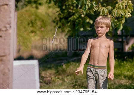 Concentrated Sporty Young Boy Training With Throwing Knife