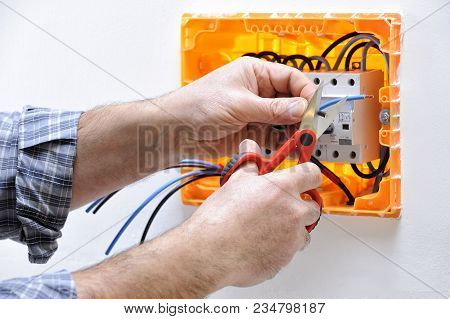 Electrician Technician At Work On A Residential Electrical Panel, Prepares The Cable With Profession