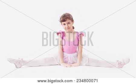 Cute, Little And Beautiful Young Ballerina Girl Dancing On White Background. Studio Shoot