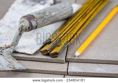 Laying And Cutting Tiles. Tools And Building Materials At A Working Position. Tiles For Industrial A