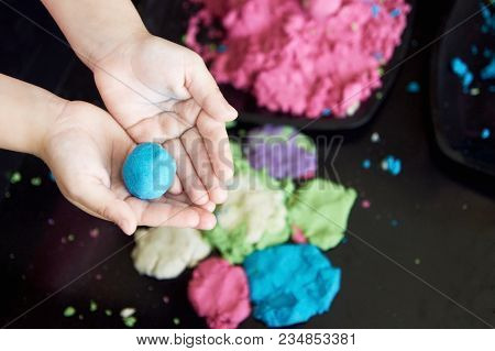 Girl Plaing Magic Kinetic Sand. Black Box.