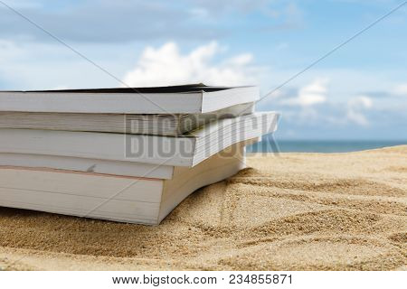 Close Up Book On Sand Of Beach On Blur Beautiful Sky Background, Summer Concept