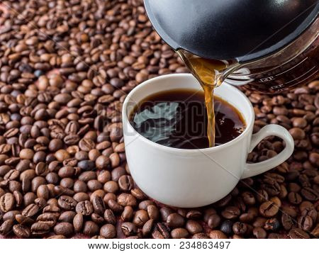 Cup And Pot Of Coffee On Coffee Beans Background