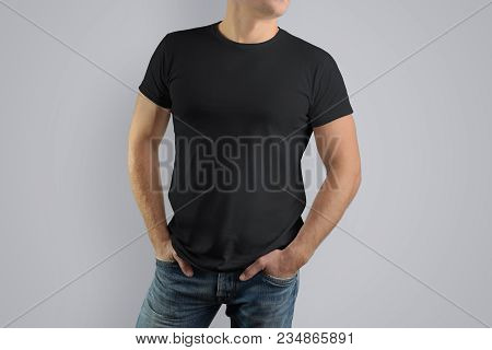 Mockup  Black T-shirt On A Strong Man In Blue Jeans.