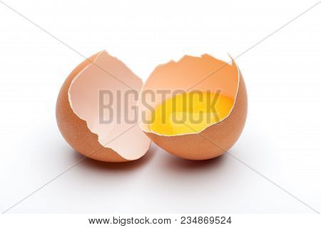 Cracked Raw Brown Egg, Egg Yolk In Egg Shell On White Background