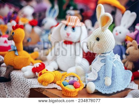 Three Handmade Knitted Hens And Rabbits On Beige Background As Easter Decoration