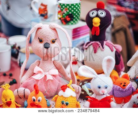 Three Handmade Knitted Hens And Rabbits On Beige Background As Easter Decoration