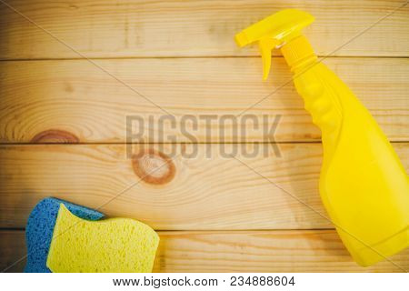 Cleaning House Or Office Concept. Yellow Plastic Bottle With Spayer And Sponges On A Natural Wooden 
