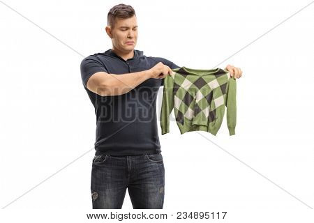 Upset young man with a shrunken blouse isolated on white background