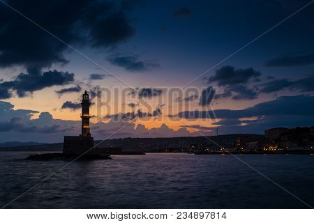 A Beautiful Night Sky Behind A Shining Lighthouse. Chania, Crete, Greece