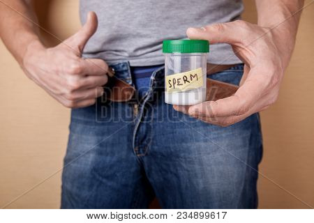 Sample Of Sperm For Analysis Of Infertility. Man Is Holding A Jar Of Analysis And Hands Showing  Thu