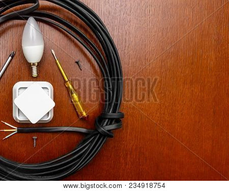 Wire And Electric Tools, A Light Bulb, A Socket, A Screwdriver, A Top View On The Wooden Table. Plac