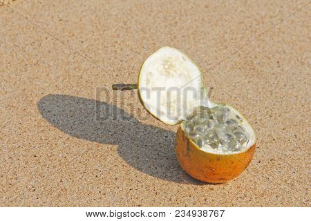 One Orange Open Passion Fruit With Seeds. Passion Fruit Closeup On The Beach, On The Sand And On The
