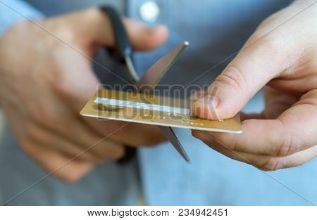 Man Cutting Gold Credit Card With Scissors.