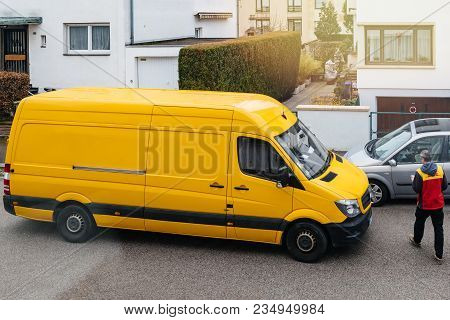 Paris, France - Mar 30, 2018: Courier Enters Dhl Yellow Delivery Van After Delivering The On Time De