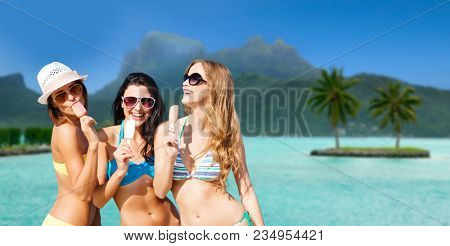 summer holidays, vacation, travel and tourism concept - group of smiling young women eating ice cream at touristic resort over exotic bora bora island beach background