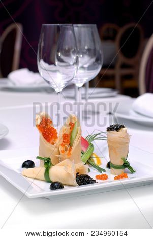 Caviar with pancakes on a white plate. Restaurant