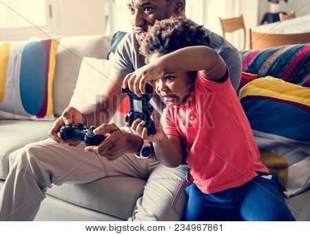 Dad and son playing game at living room together