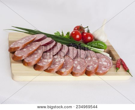 Still Life With Sliced Smoked Sausage Greens And Tomatoes On A White Background. Can Be Used For Ban