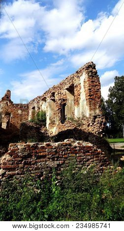 An Old Broken Brick Wall With Cracks. Ruined Wall Of The Old Cathedral.